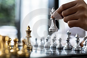 Person playing chess board game, business woman concept image holding chess pieces like business competition and risk management,