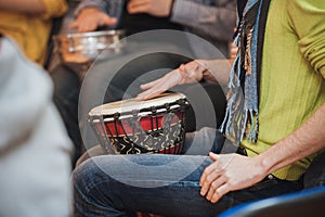 Person playing on Jambe Drum no face photo