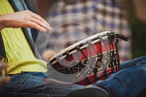 Person playing on Jambe Drum no face