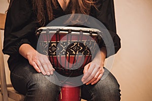 Person playing on Jambe Drum no face photo