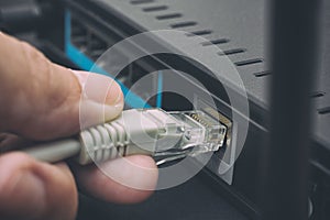 Person plugging in cable to wireless router