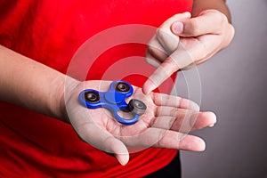 Person pointing dislodged weight from fidget spinner, dangerous