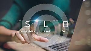 A person is pointing at a laptop screen that says SLB