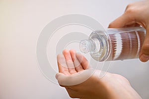 Person pouring cologne on their hands for personal hand cleaning