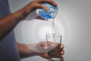 person pouring water in glass over white background