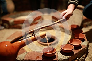 Person pouring wine from qvevri using Orshimo