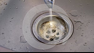 A person pours granules for cleaning sewer pipes from debris and hair into the sink. Cleaning a dirty, clogged siphon