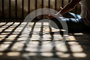person practicing yoga, window bars casting shadow