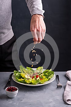 Person preparing a green salad .