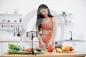 Person preparing meal out of vegetable on cell phone camera