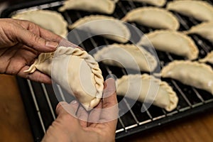 A person is preparing vegan and vegetarian Argentinian empanadas with a stuffing