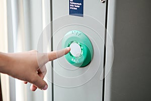 The person presses the stop button in the train.