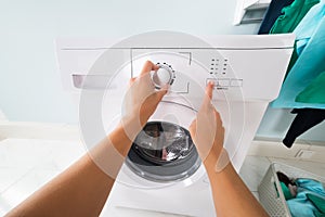 Person Pressing Button Of Washing Machine