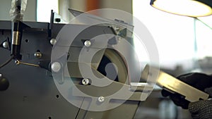 A person in production works on a grinding machine and polishes welding on details