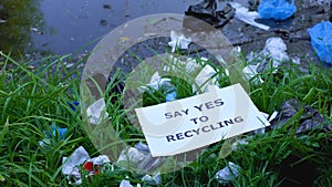 Person putting cardboard with say yes to recycling phrase on open dumping