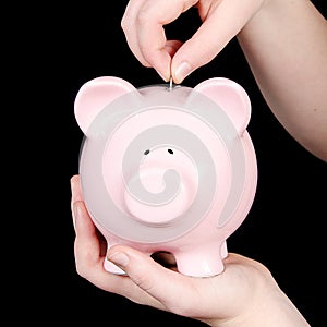 Person putting money in piggy bank