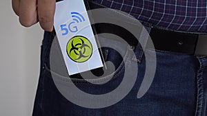 Person putting a smartphone in his pocket covered with foil