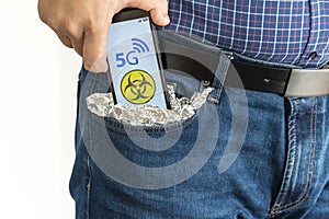 Person putting a smartphone in his pocket covered with foil