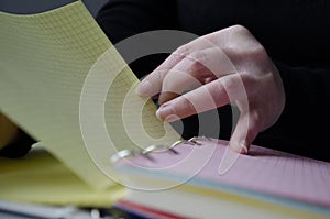 A person reading books near the window. Hands turns over book page