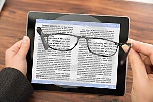 Person reading e-book with spectacles