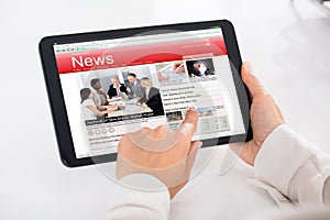 Person Reading News On Digital Tablet