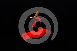 Person in a red dervish costume spinning on a black background