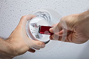 Person Removing Battery From Smoke Detector