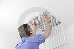 Person Removing Ceiling Air Filter