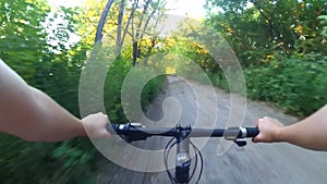 Person riding a cycle on a wide dirt road at dawn sunset