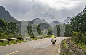 a person is riding their motorcycle down the road and has very a mountainous landscape behind