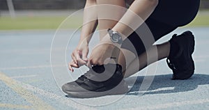 Person, runner and tie shoelace on race track or starting line for exercise safety, speed or competition. Athlete, feet