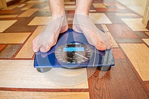 person's bare feet standing on the digital weghs scale, diet concepts