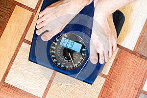 person's bare feet standing on the digital weghs scale, diet concepts