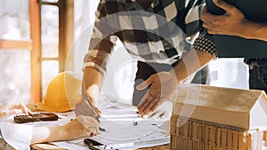 Person's engineer Hand Drawing Plan On Blue Print with architect equipment.