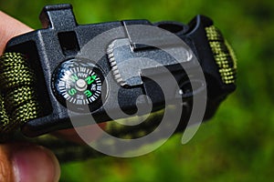 person's hand with compass in the forest photo