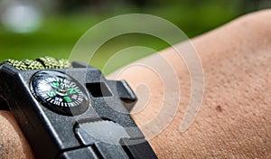 person's hand with compass in the forest photo