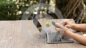 person's hand deftly manipulated both mobile phone and notebook, engaged in the realm of online shopping.