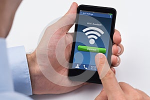 Person's Hand Holding Mobile Phone With WiFi Signal