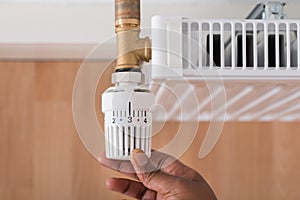 Person's Hand Holding Radiator Thermostat