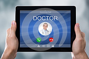 Person`s Hand Holding Tablet With Doctor`s Incoming Call