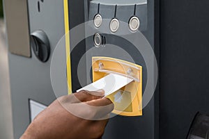 Person`s Hand Inserting Ticket Into Parking Machine