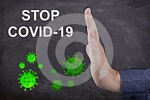 Person's hand showing Stop COVID-19 text - global pandemic concept