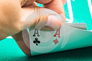 Person's hand showing two aces at a poker game