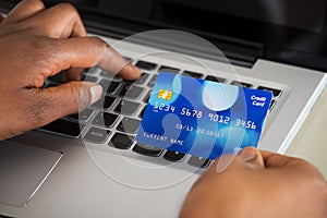 Person's Hand Using Debit Card While Shopping Online