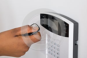 Person`s Hand Using Remote To Operate Entrance Security System