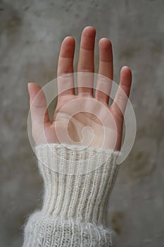 A person& x27;s hand with a white knit glove on it, AI