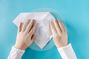 Person`s hands folding a paper airplane