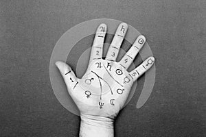 Person`s left palm with drawn lines and chiromancy symbols