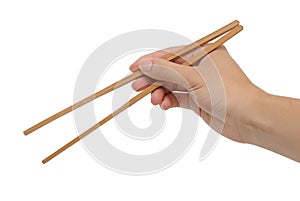 Person's right hand using bamboo chopsticks