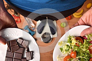 Person on scale showing plates with healthy and unhealthy food